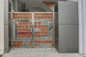 Una entrada moderna de edificio con una reja metálica y piso de baldosas.