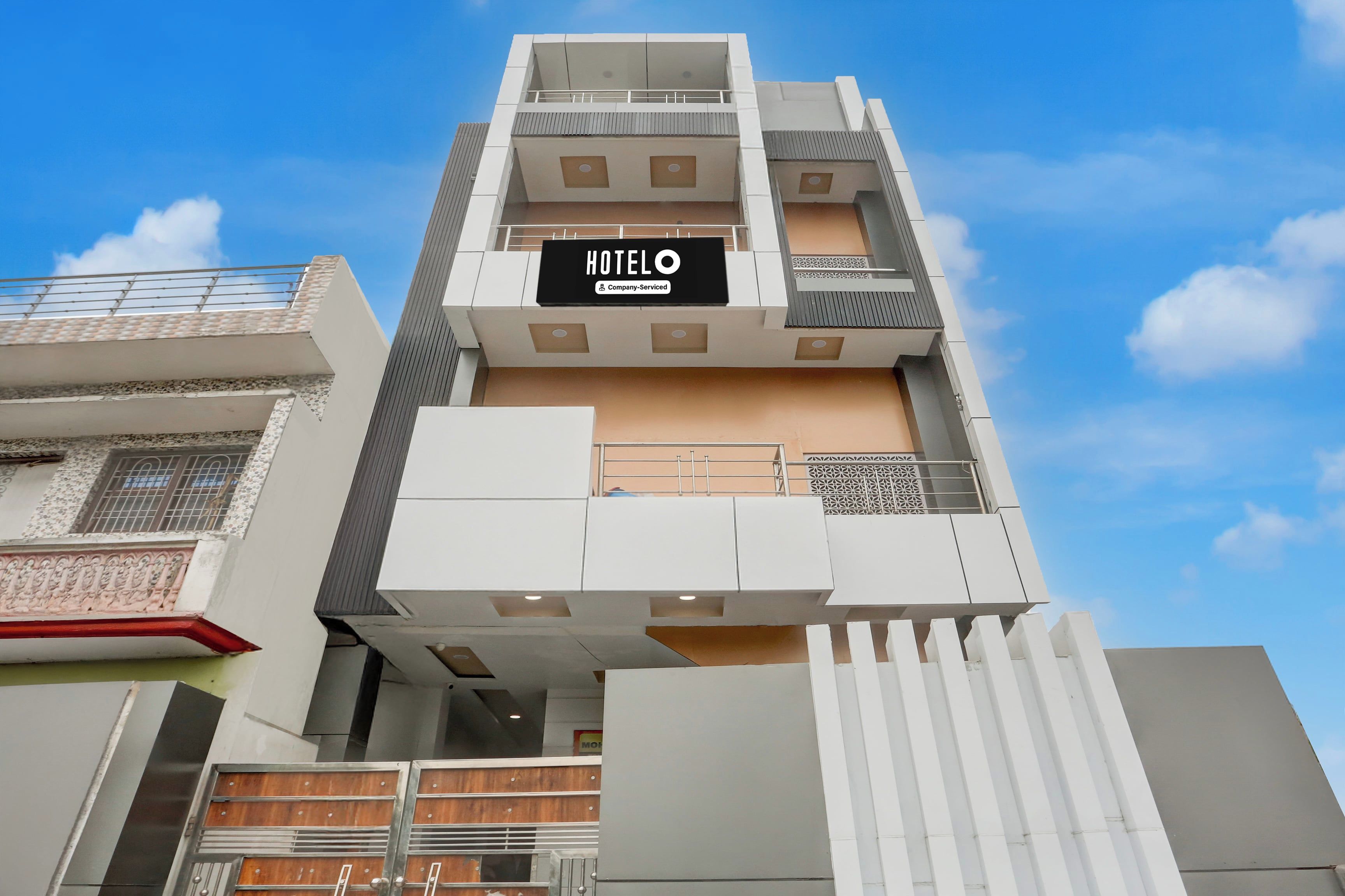 Un edificio de hotel moderno con un letrero destacado que dice 'HOTEL' y 'Company Serviced'.