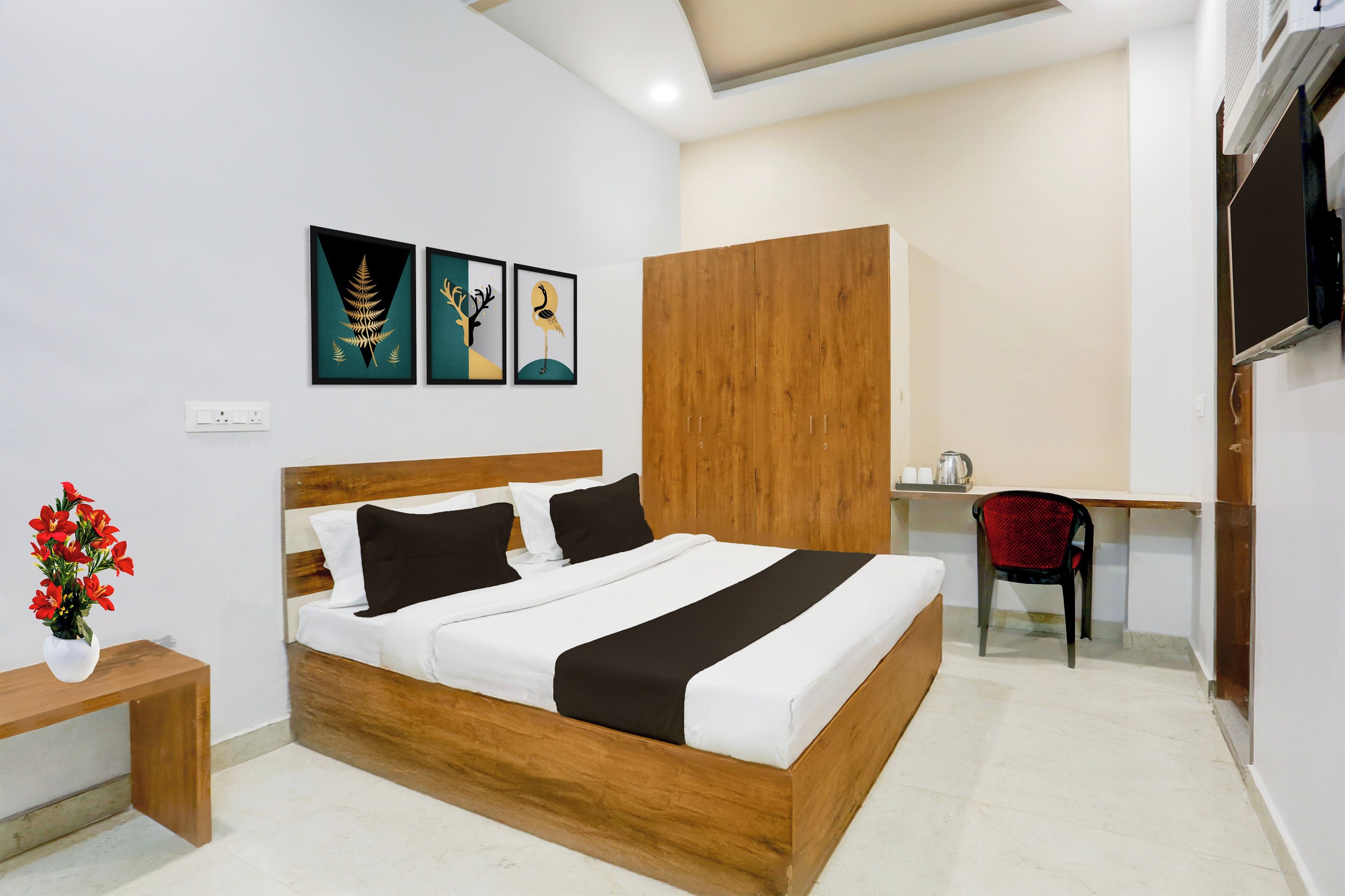 Una habitación de hotel con una cama de madera, un escritorio y un televisor.