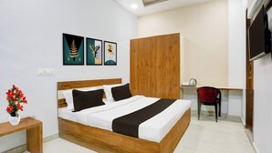 A hotel room with a wooden bed, a desk, and a TV. - OYO Hotel O Bareilly Near Bus Stand (Bareilly)