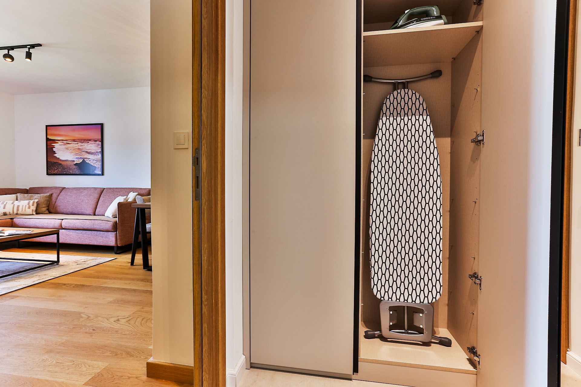 A room with a wooden floor, a sofa, a coffee table, and a wall-mounted picture.