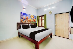 Una habitación de hotel con una cama, un cuadro, un reloj y una puerta.
