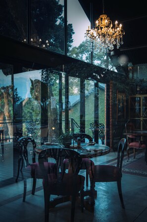 A dining area with a round table, chairs, and a chandelier. - The Bohemian Guesthouse (Tzaneen)