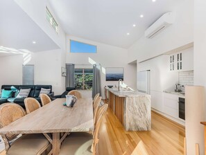 Ein modernes Interieur mit Essbereich, Küche und Sitzgelegenheiten.