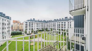 Un edificio residencial con varios balcones, un patio con vegetación y un parque infantil.