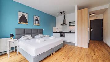 Un dormitorio moderno con una cama grande, una mesita de noche y una mesilla.
