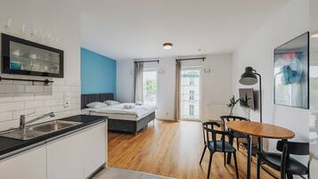 Un apartamento moderno con cocina, comedor, dormitorio y un amplio ventanal.