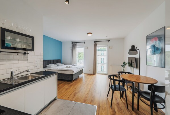 Un apartamento moderno con cocina, comedor, dormitorio y un amplio ventanal.