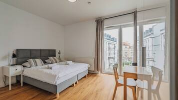 Ein modernes Schlafzimmer mit Bett, Nachttischen, Schreibtisch und Stuhl.