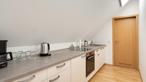 Eine moderne Küche mit Backofen, Kaffeemaschine und Wasserkocher.