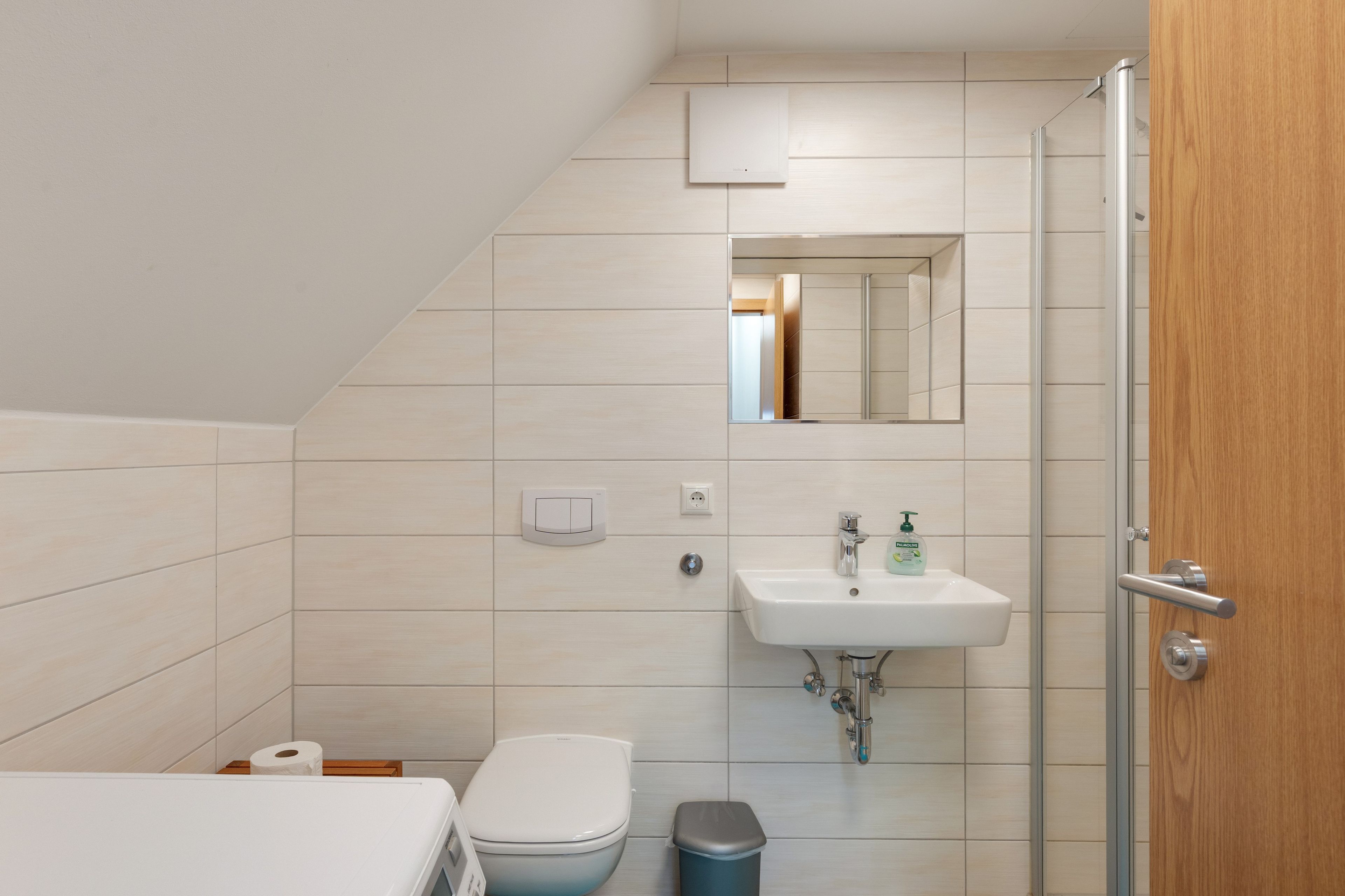 Ein modernes Badezimmer mit Toilette, Waschbecken und Dusche.