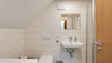Ein modernes Badezimmer mit Toilette, Waschbecken und Dusche.