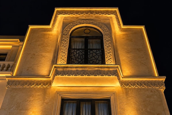 A building facade with a prominent arched window and decorative moldings.