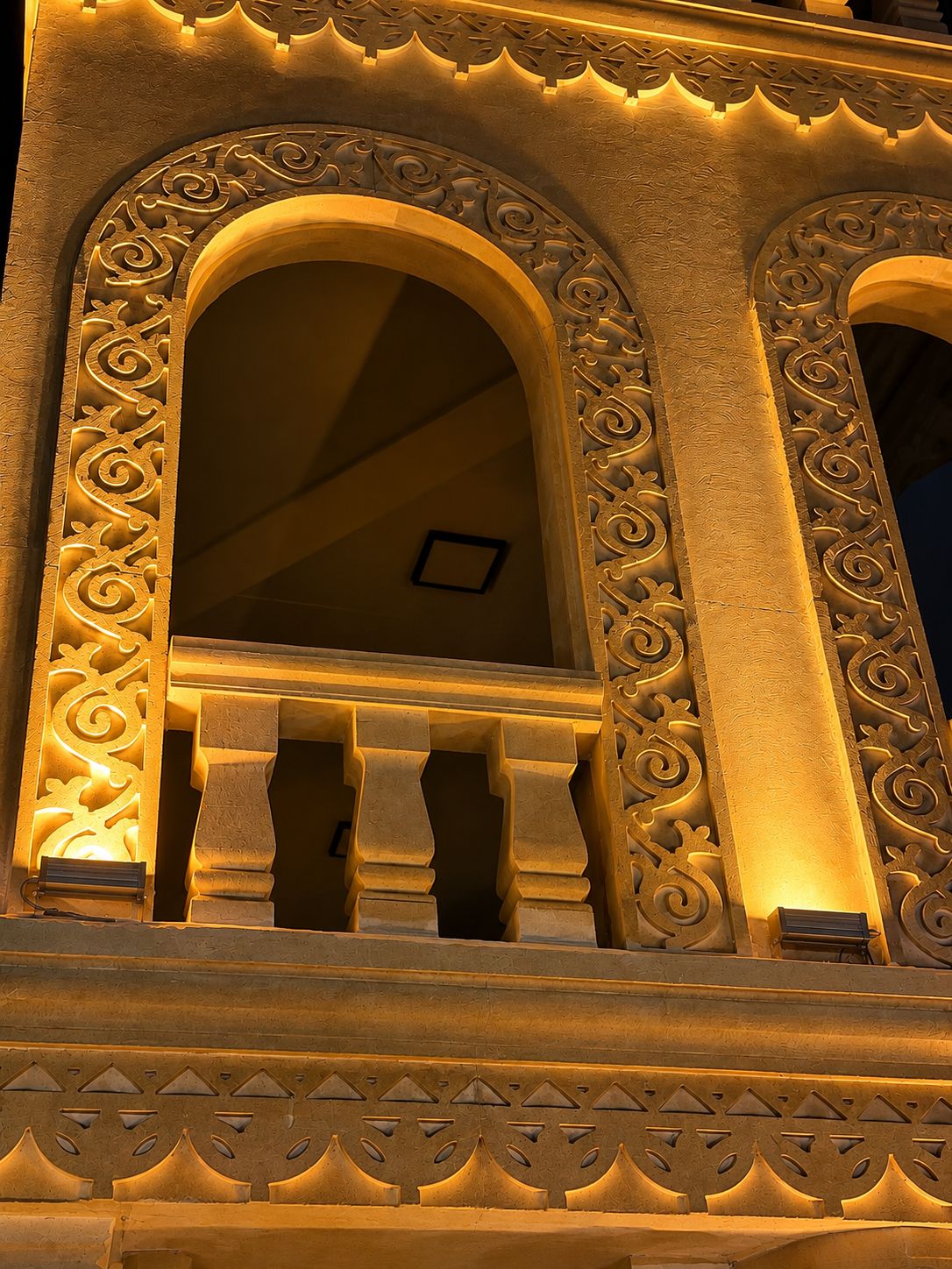 A building facade with ornate architectural details, including carved patterns and a series of arches.