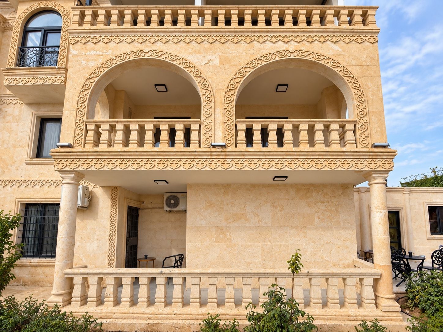 Un edifici de diversos pisos amb un balcó, finestres apuntades i una façana decorativa.