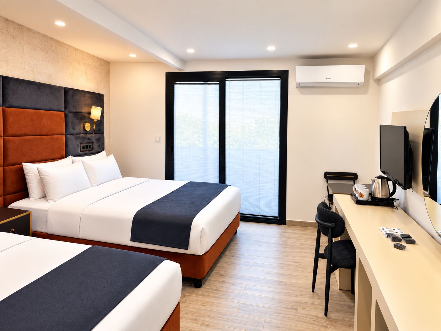 A hotel room with two beds, a desk with a chair, a television, and an air conditioning unit.