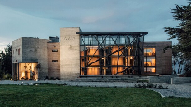 Een modern gebouw met een glazen gevel en een trap naar de ingang.
