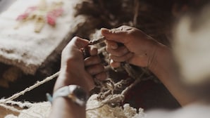 Hands holding a piece of yarn, suggesting a crafting activity. - Hotel Awa (Puerto Varas)