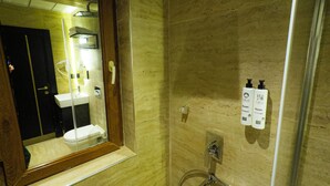 Ein Badezimmer mit Dusche, Waschbecken und Spiegel.