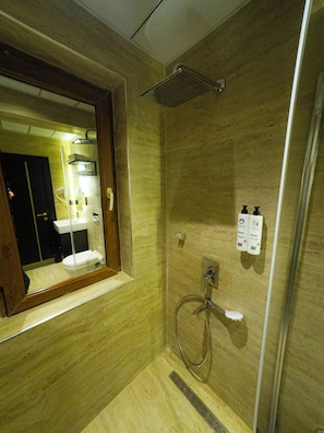 Ein Badezimmer mit Dusche, Waschbecken und Spiegel.