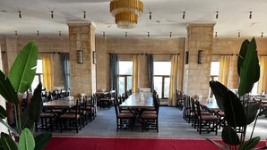Ein Konferenzraum mit einem langen Tisch, Stühlen, einem roten Teppich und Zimmerpflanzen.