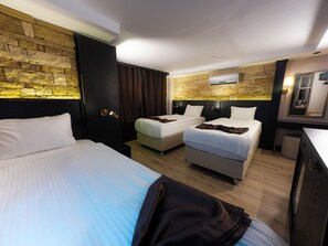 A hotel room with two beds, a wardrobe, a mirror, and a stone wall. - Buyuk Mardin (Mardin)