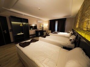 A hotel room with two beds, a TV, a desk, and a wardrobe. - Buyuk Mardin (Mardin)