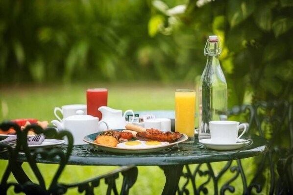 A table set outdoors with breakfast items, a pitcher, a bottle, and a cup. - ama Stays & Sluice House Lonavala (Mawal)