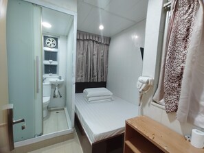 A hotel room with a bed, a bedside table, a bathroom with a toilet, sink, and mirror, and a hairdryer on the wall. - HOO Sang Hotel (Kowloon)