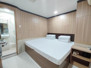 A bedroom with a bed, a bedside table, a mirror, and a wardrobe. - HOO Sang Hotel (Kowloon)
