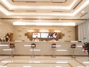 A hotel reception area with a modern design, a reception desk, and a digital screen displaying information. - Greentree INN Zhangjiakou High Speed Railway Station (Zhangjiakou)