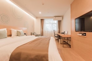 Ein Hotelzimmer mit einem Bett, einem Schreibtisch, einem Sessel, einem Fernseher und einer Klimaanlage.