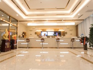 A hotel reception area with a modern design, a reception desk, and a television screen. - Greentree INN Zhangjiakou High Speed Railway Station (Zhangjiakou)