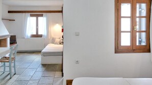 Ein Schlafzimmer mit einem Bett, einer Holztür und einem Fenster.
