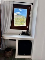 Un baño pequeño con ventana, lavamanos, hervidor y lavadora.