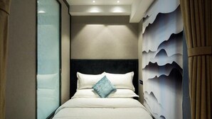 Ein Hotelzimmer mit einem Bett, einem Kopfteil und einer Wand mit wellenförmigem Design.