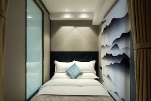 Une chambre d’hôtel avec un lit, une tête de lit et un mur orné d’un motif ondulé.