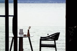 A view of a lake with a table and a chair facing it, suggesting a dining or relaxation area.