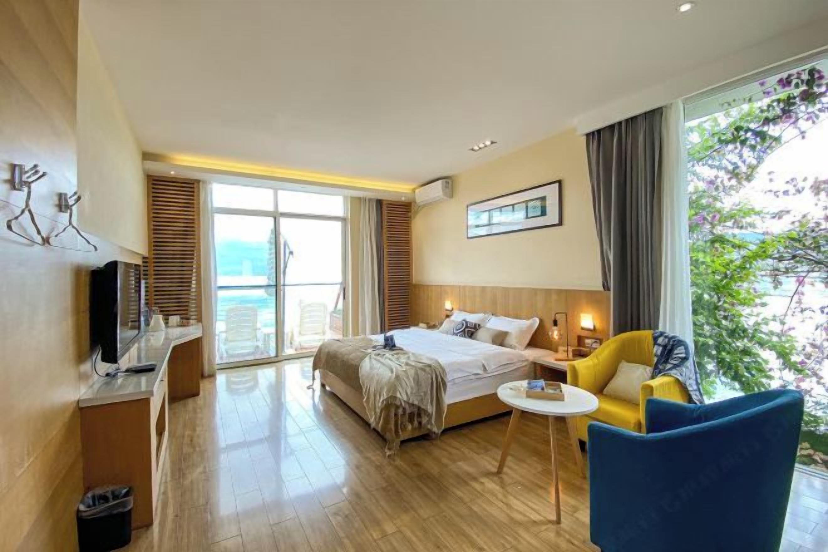 Habitación de hotel con una cama, un escritorio, una silla y vistas al exterior.