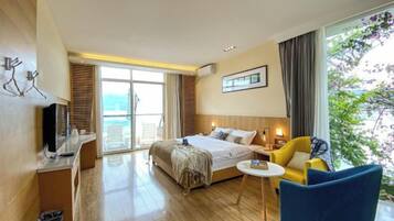 Habitación de hotel con una cama, un escritorio, una silla y vistas al exterior.