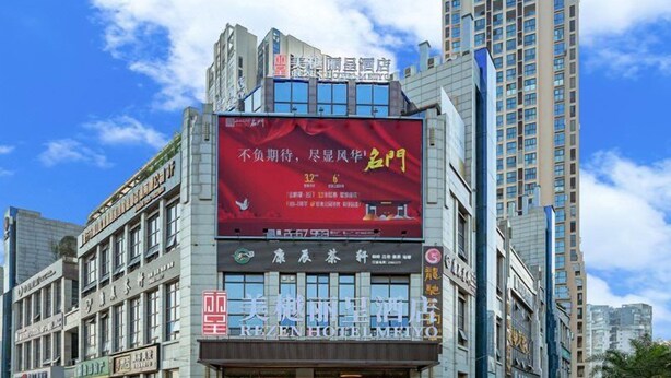 A multi-story building with a prominent red advertisement on the facade. - Rezen Hotel Meiyo (Suining)