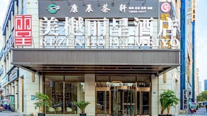 A hotel entrance with a revolving door, potted plants, and a clear view of the street. - Rezen Hotel Meiyo (Suining)