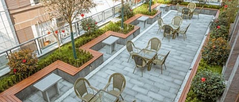 A rooftop terrace with outdoor seating and planters.