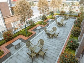 Una terraza en la azotea con mobiliario exterior y jardineras.