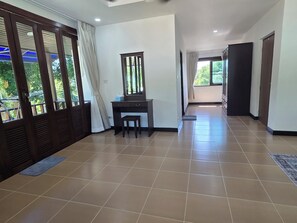 A hallway with a desk, chair, and a large window with curtains. - Peaceful & Spacious 2-Bedroom Villa with Large Garden in Central Chaweng (Bophut koh samui)