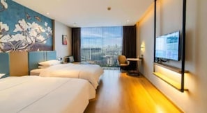 Une chambre d’hôtel avec deux lits, une télévision, un bureau et une vue sur la ville.