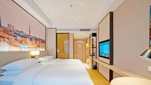 Quarto de hotel com uma cama grande, televisão e pintura de uma paisagem urbana.