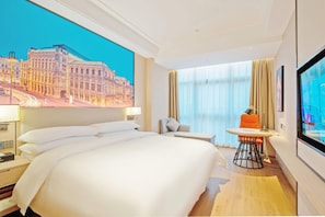 Une chambre d’hôtel avec un grand lit, un bureau, une chaise, une télévision et une vue sur le paysage urbain.