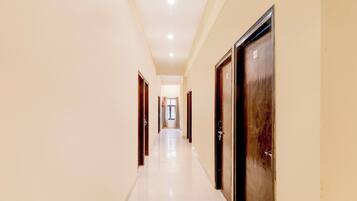 A corridor with doors on both sides, leading to a room with a window.