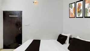 Quarto de hotel com cama, porta e obras de arte fixadas na parede.
